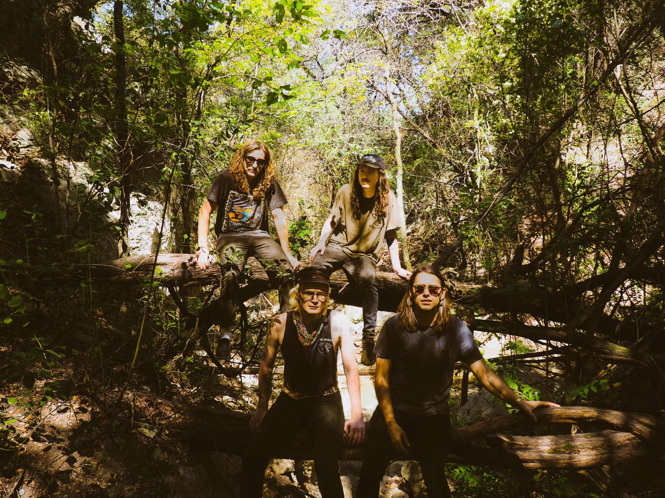 Photoshoot of four people in the woods dressed in black